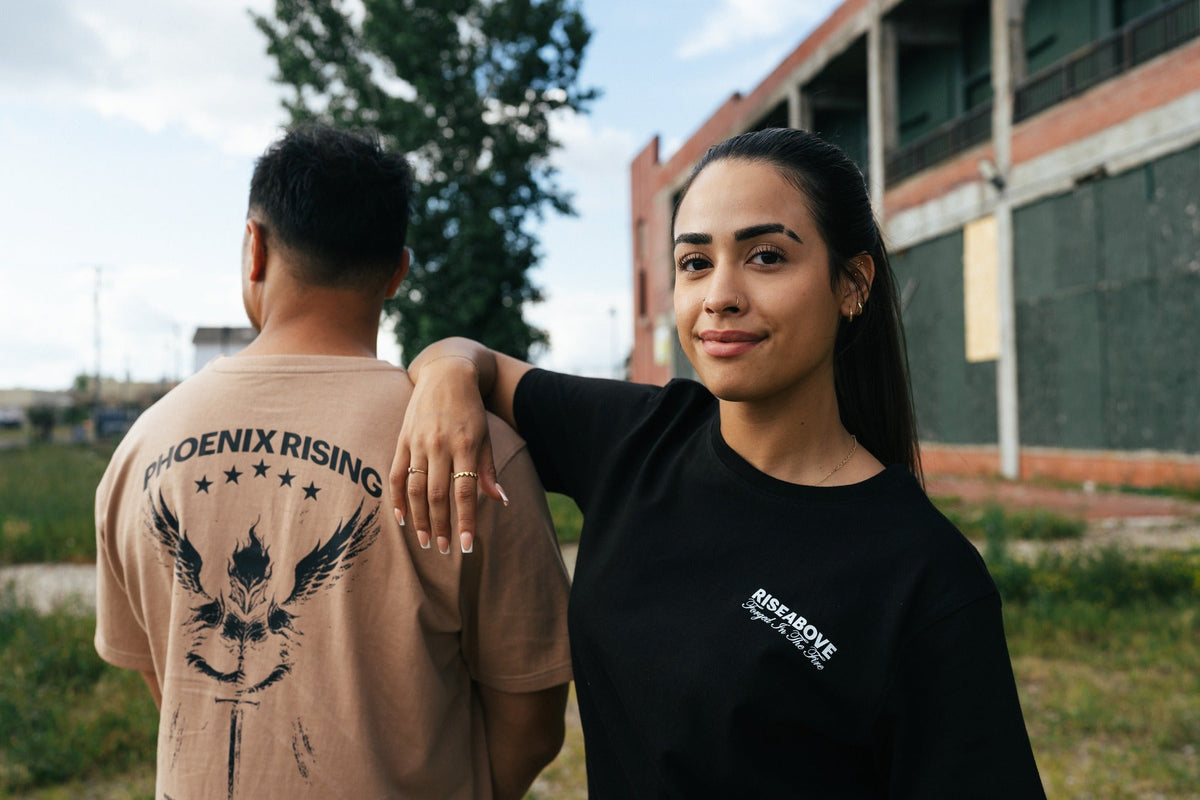Two people wearing Riseabove resilience apparel, Phoenix Rising T-shirt design visible, mental health awareness clothing
