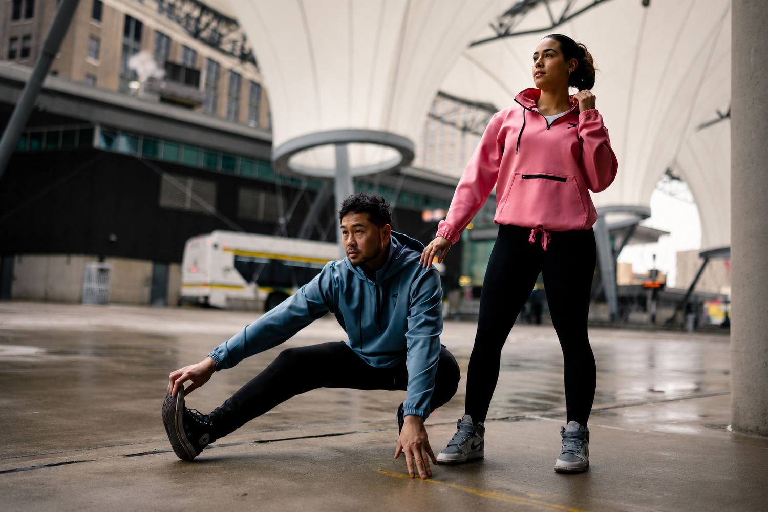 Two athletes wearing RISEABOVE performance apparel in an urban setting, representing resilience, strength, and the belief that every story matters.