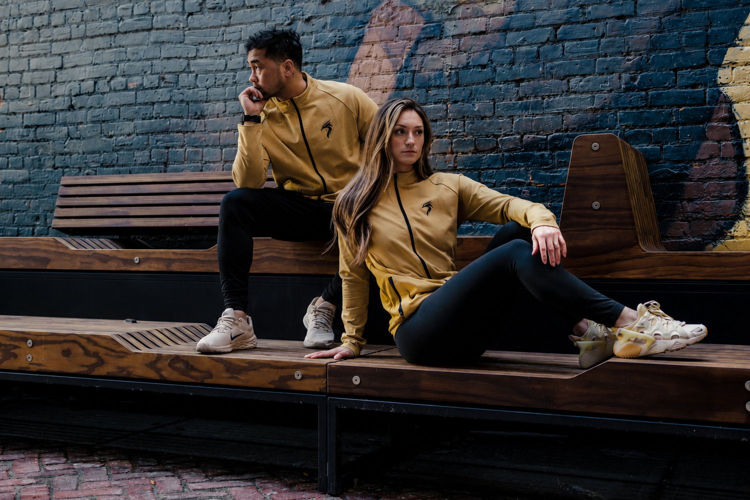 Two athletes wearing RISEABOVE performance apparel in an urban setting, representing resilience, confidence, and wearing your story with purpose